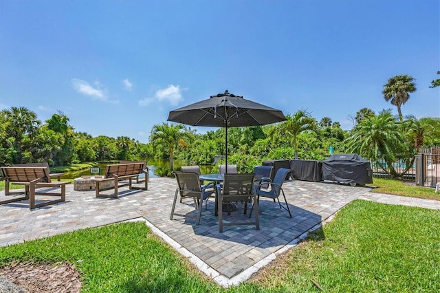 view of patio with a fire pit, a water view, and grilling area