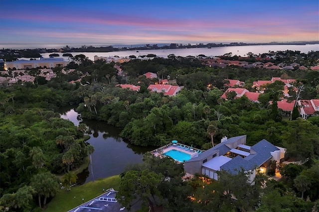 aerial view at dusk featuring a water view