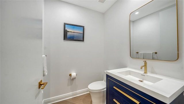 bathroom featuring toilet, wood-type flooring, and vanity