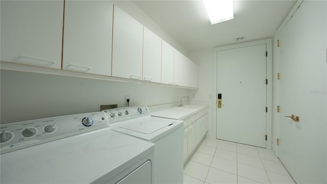 laundry area with cabinets, light tile patterned floors, sink, and independent washer and dryer