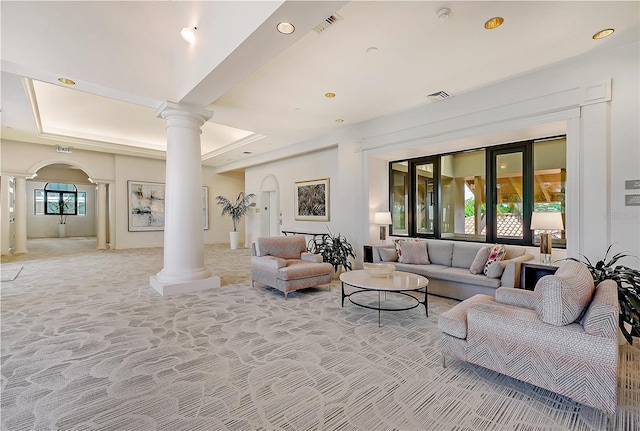 living room with a raised ceiling and decorative columns