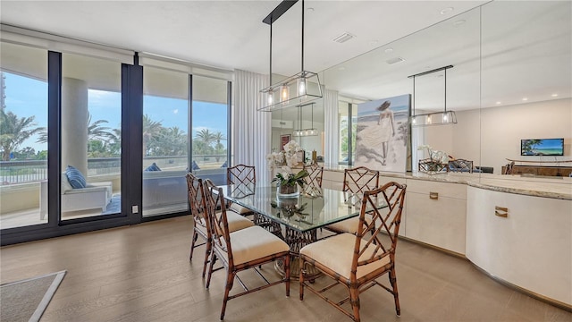 dining area featuring a wall of windows and light hardwood / wood-style flooring