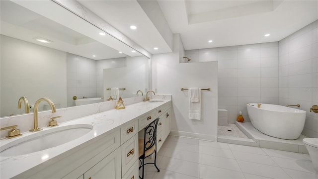 bathroom with a raised ceiling, vanity, tile patterned flooring, and separate shower and tub