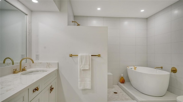 bathroom with tile patterned floors, a bathtub, vanity, and tile walls