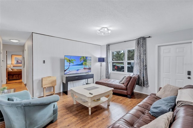 living room with light hardwood / wood-style flooring and a textured ceiling