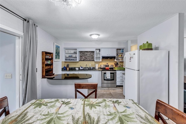 kitchen featuring white refrigerator, stainless steel electric stove, fume extractor, sink, and light tile flooring