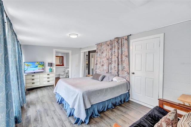 bedroom with ensuite bathroom and wood-type flooring