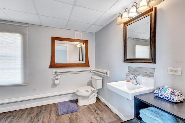 bathroom featuring sink, wood-type flooring, toilet, and a drop ceiling