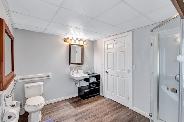 bathroom with toilet, hardwood / wood-style flooring, and a paneled ceiling