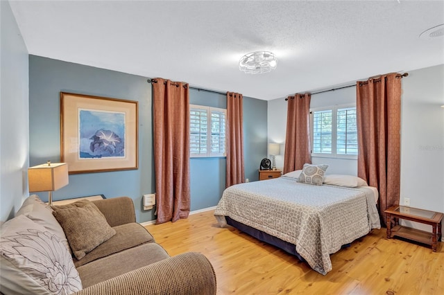 bedroom with light hardwood / wood-style floors and multiple windows