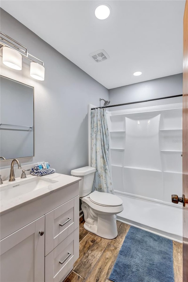 full bathroom with shower / tub combo, hardwood / wood-style floors, toilet, and vanity