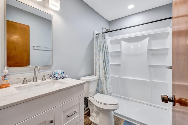 full bathroom featuring toilet, hardwood / wood-style floors, vanity, and shower / bath combo