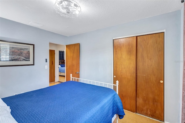 carpeted bedroom featuring a closet and a textured ceiling