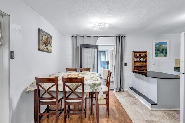 tiled dining area featuring a textured ceiling