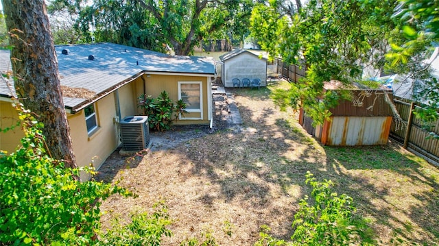 view of yard featuring a storage unit and central air condition unit