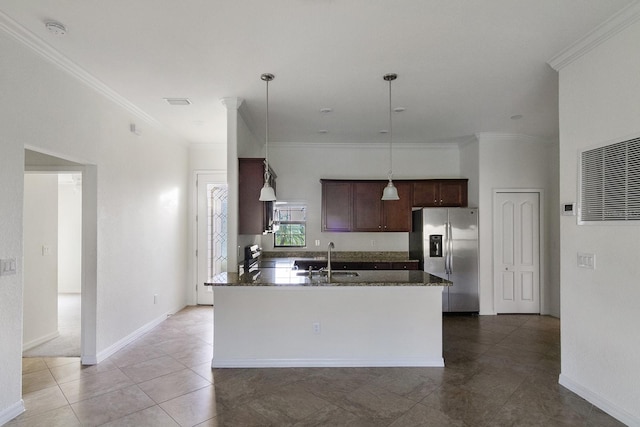 kitchen featuring hanging light fixtures, tile flooring, stainless steel fridge, dark stone countertops, and sink