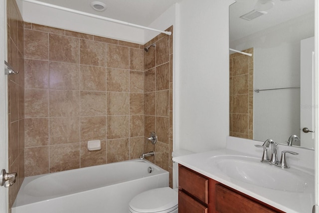 full bathroom featuring tiled shower / bath, vanity, and toilet