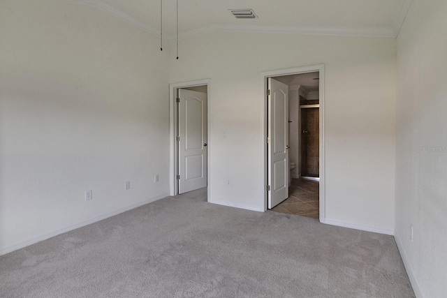 carpeted spare room with vaulted ceiling and ornamental molding