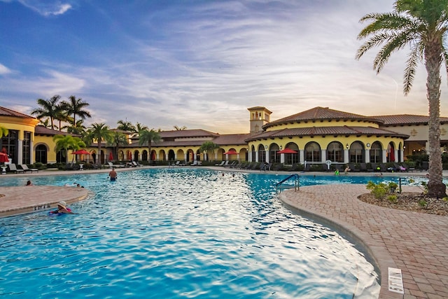 pool at dusk with a patio area