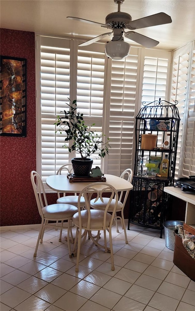 tiled dining space with ceiling fan and a wealth of natural light