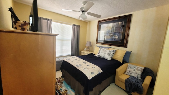 bedroom with ceiling fan and a textured ceiling