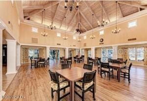 dining area featuring wooden ceiling, beamed ceiling, high vaulted ceiling, and hardwood / wood-style floors