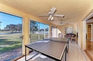 game room featuring a water view and ceiling fan