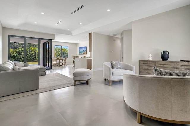 tiled living room featuring a raised ceiling