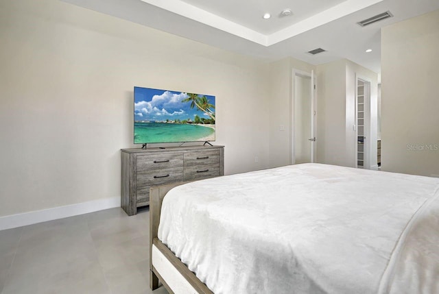 bedroom with concrete floors and a raised ceiling