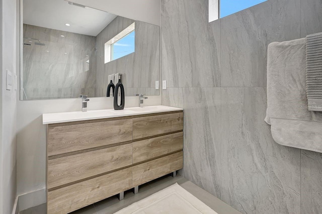 bathroom featuring vanity and tile walls