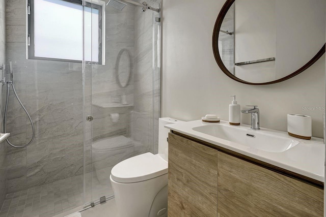 bathroom with a shower with shower door, vanity, and toilet