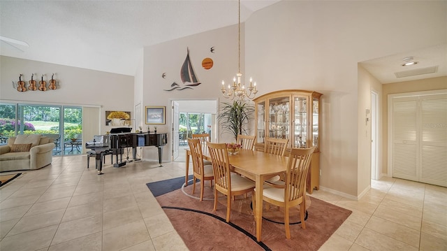 tiled dining room with high vaulted ceiling and a chandelier