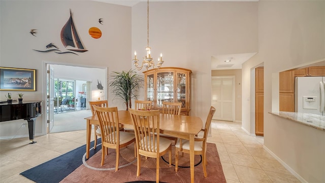 dining room featuring a towering ceiling, a chandelier, and light tile floors