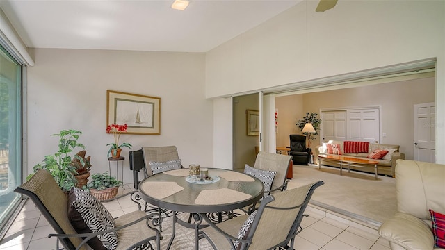 dining room featuring high vaulted ceiling and light tile floors