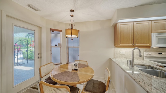 dining area featuring sink and a textured ceiling