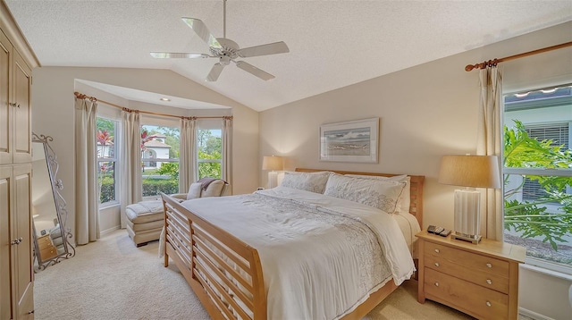 bedroom with light carpet, a textured ceiling, ceiling fan, and vaulted ceiling