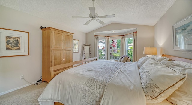 carpeted bedroom with vaulted ceiling, ceiling fan, and a textured ceiling