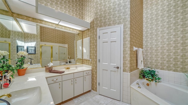 bathroom featuring lofted ceiling, a bath to relax in, tile floors, large vanity, and dual sinks