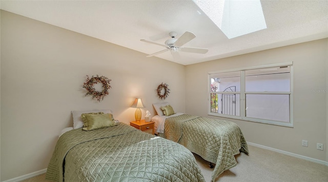 bedroom featuring carpet, ceiling fan, and a skylight