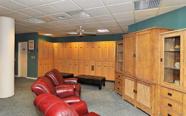 carpeted living room featuring built in shelves and ceiling fan