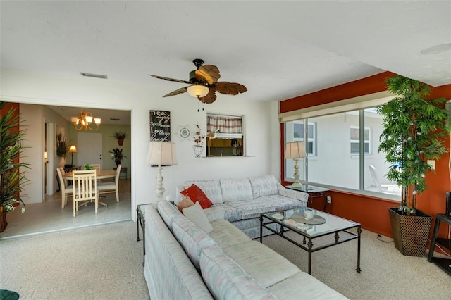 living room featuring ceiling fan with notable chandelier