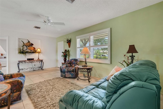 living room with tile floors, a textured ceiling, and ceiling fan