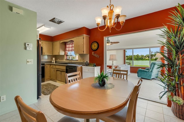 dining area featuring sink, ceiling fan with notable chandelier, light tile floors, and a textured ceiling