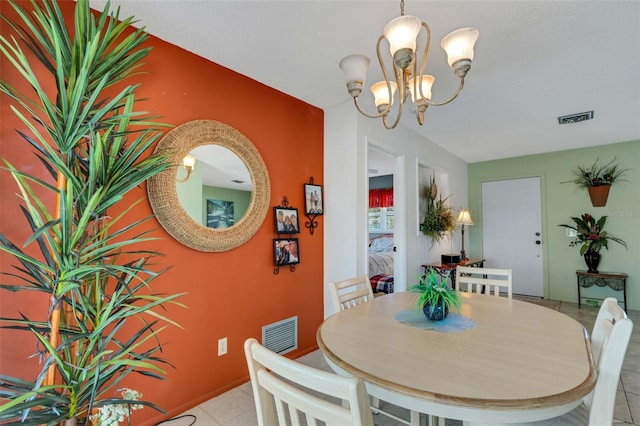 dining space featuring tile floors and a chandelier