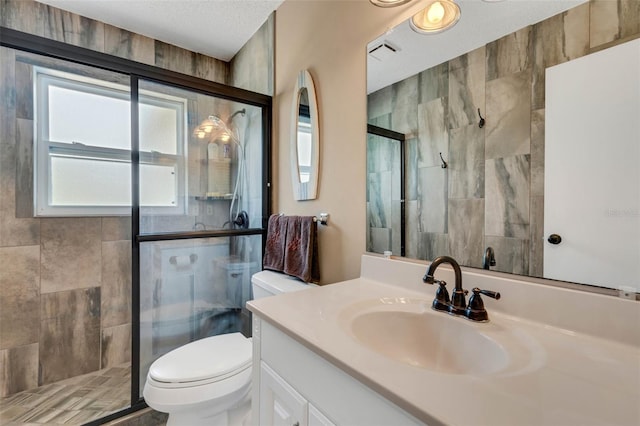 bathroom featuring walk in shower, a textured ceiling, oversized vanity, and toilet