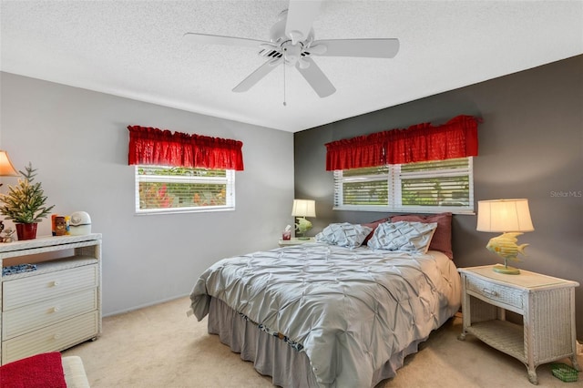 bedroom with a textured ceiling, ceiling fan, and light colored carpet