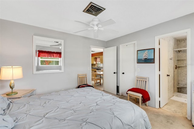 carpeted bedroom with ensuite bathroom and ceiling fan