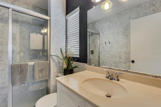 bathroom with a shower with door, toilet, and vanity with extensive cabinet space