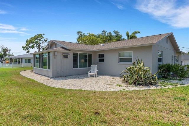 rear view of property featuring a sunroom and a lawn