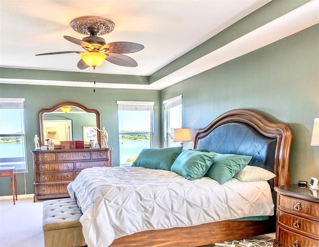 carpeted bedroom featuring ceiling fan and multiple windows